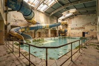 Intérieur abandonné du parc aquatique Aqualud au Touquet avec toboggans vides et bassins à l'abandon en 2026